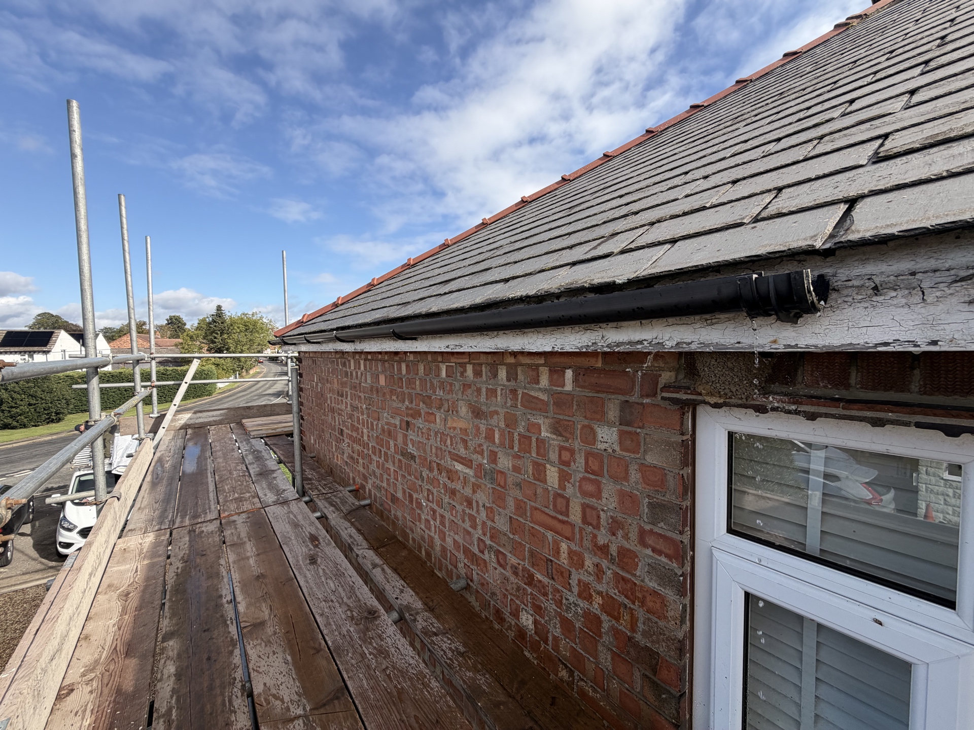 Roof access and scaffold along the side elevation before renewal