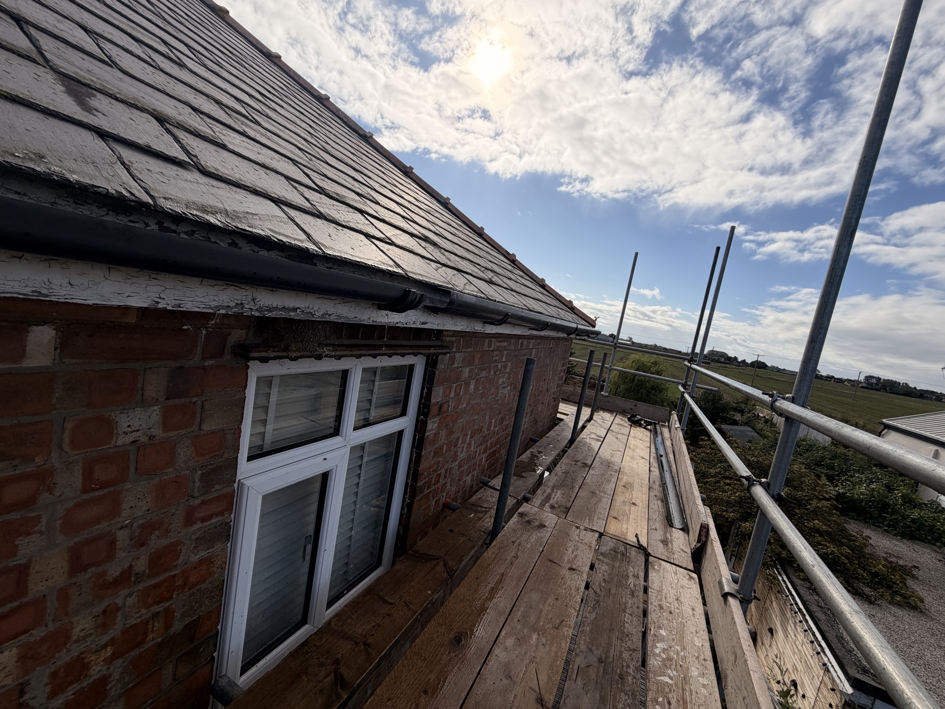Scaffolded side elevation beside the existing slate roof