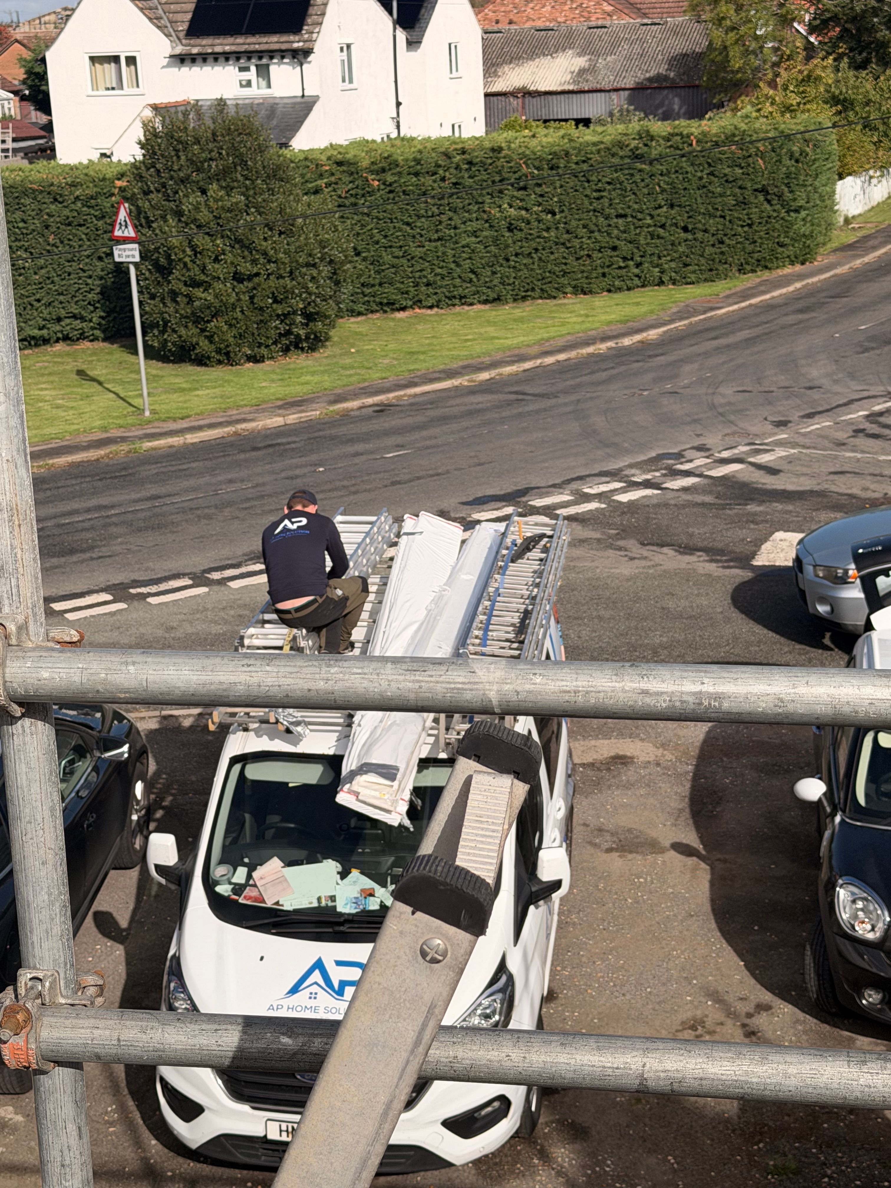 Roof work viewed from above with scaffold and materials