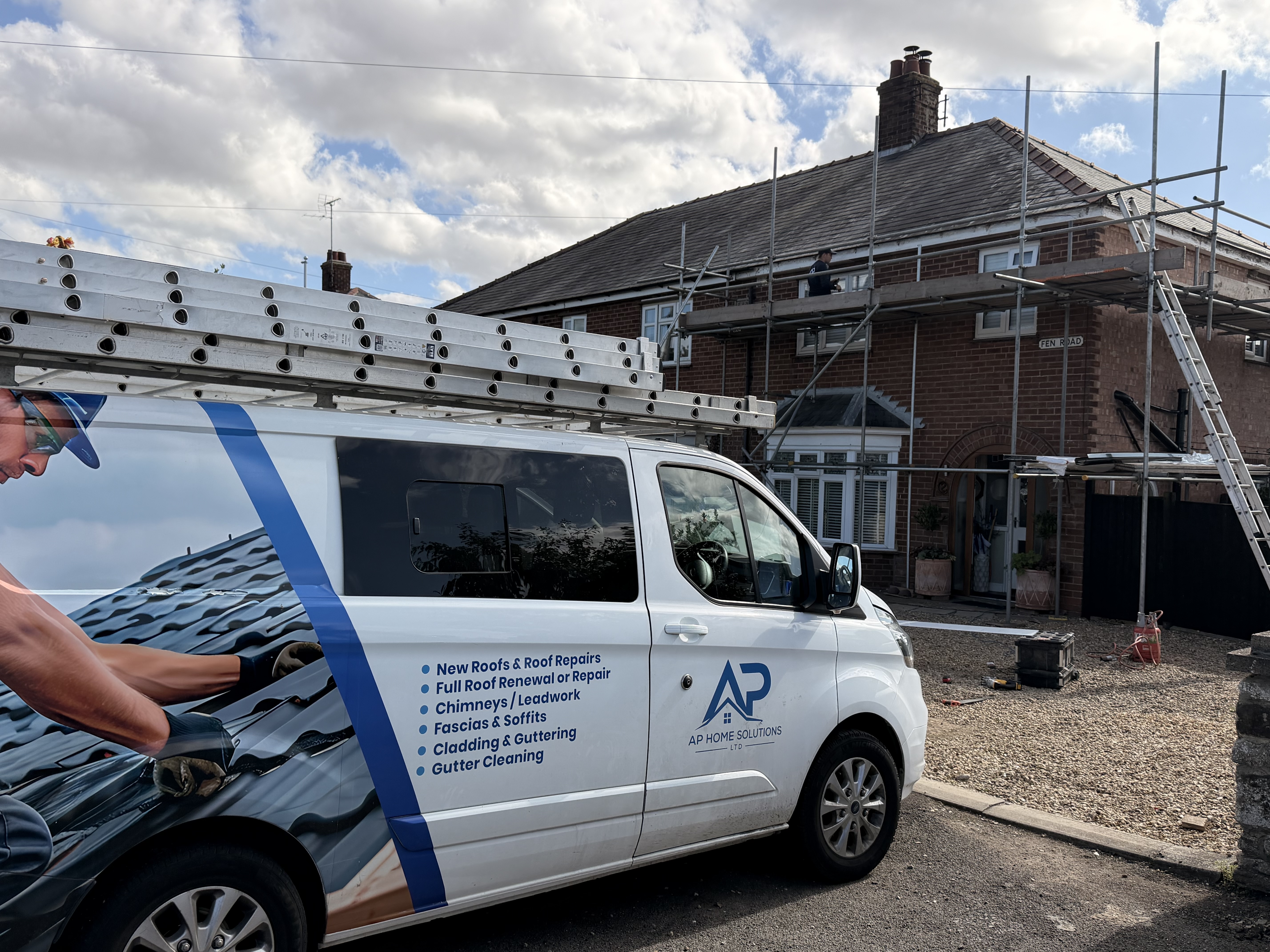 AP Home Solutions van beside a scaffolded roofing project