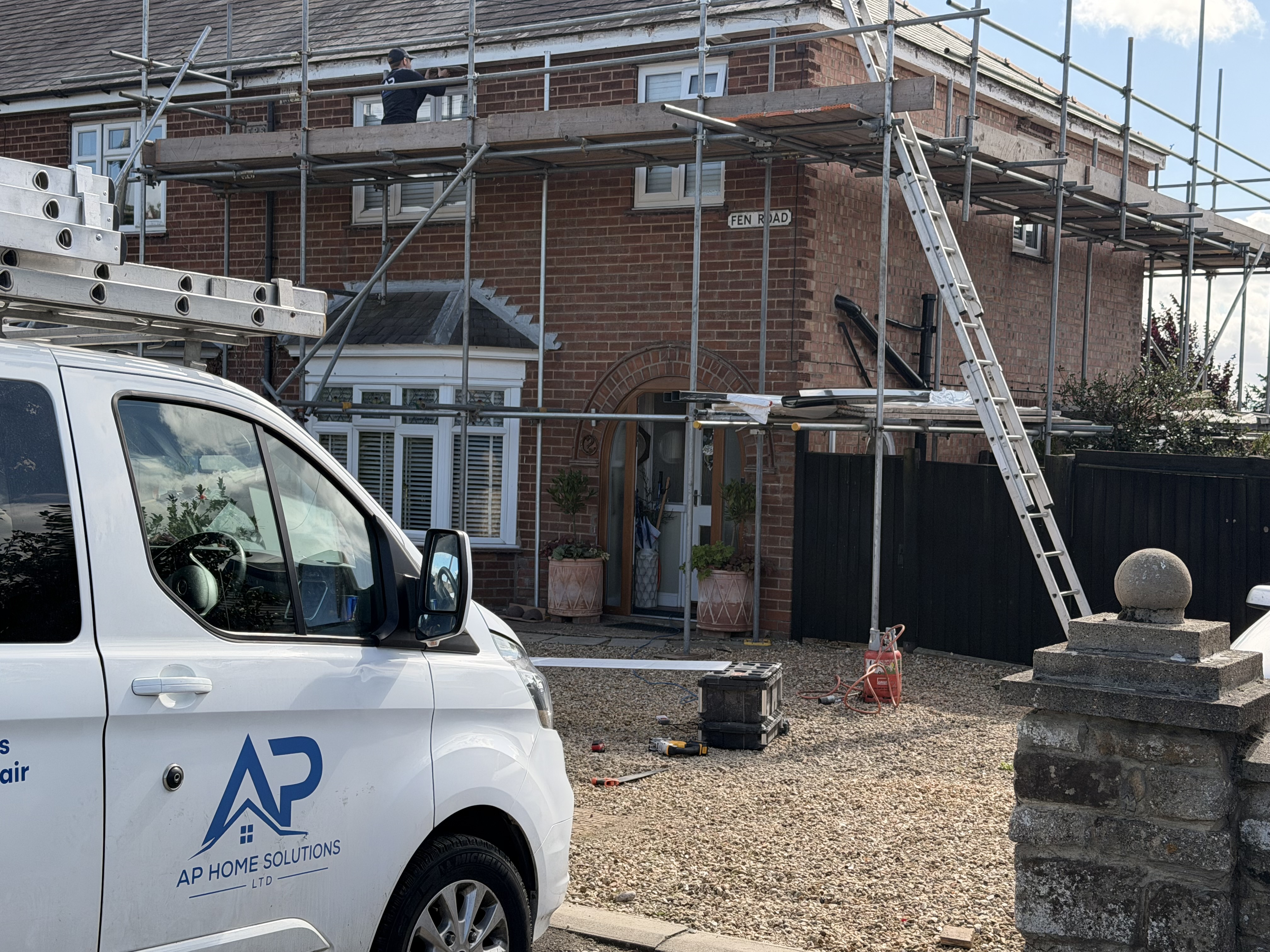 Scaffolded house with the existing roof under renewal