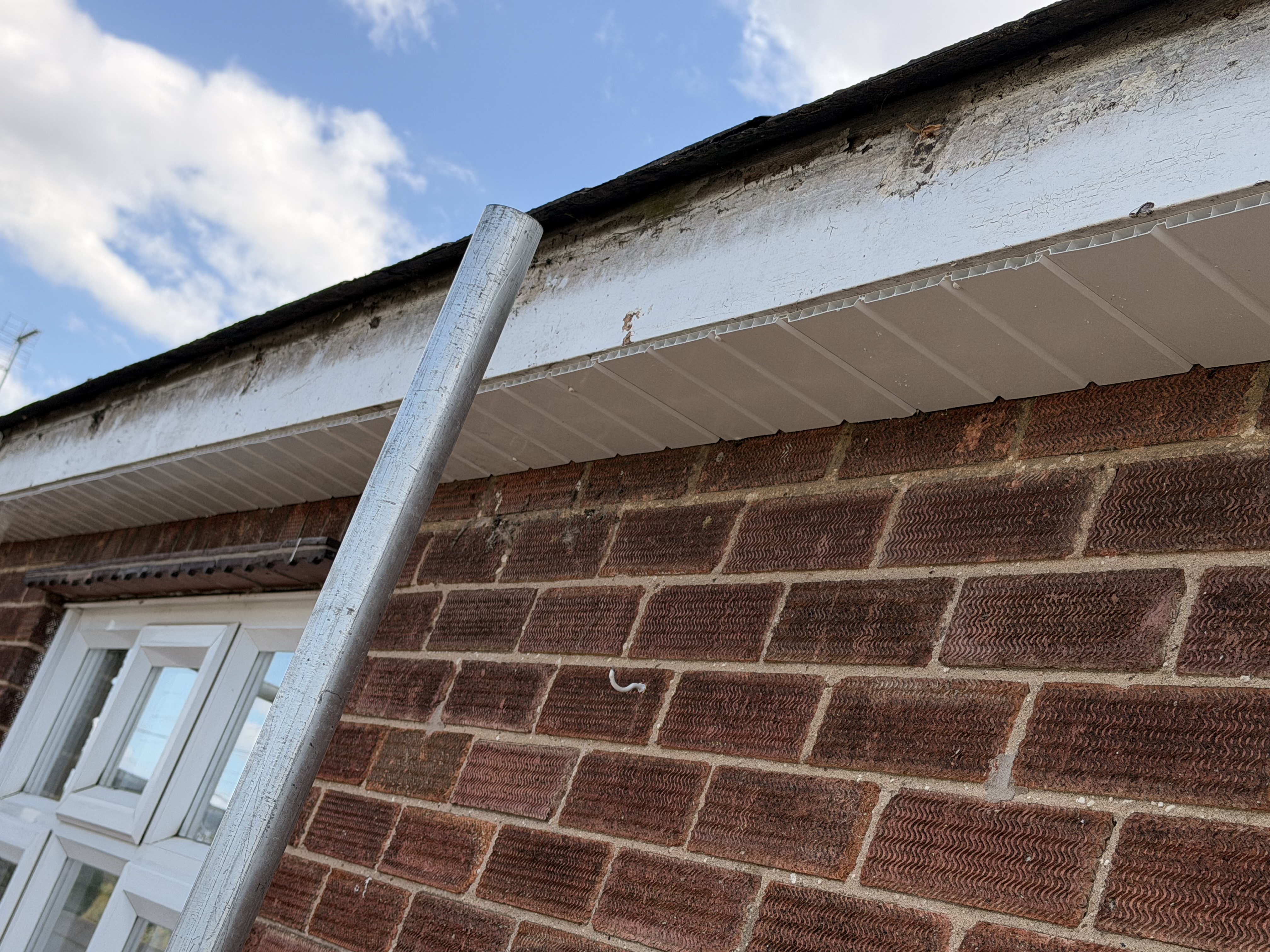 White roofline and gutter edge detail on brickwork