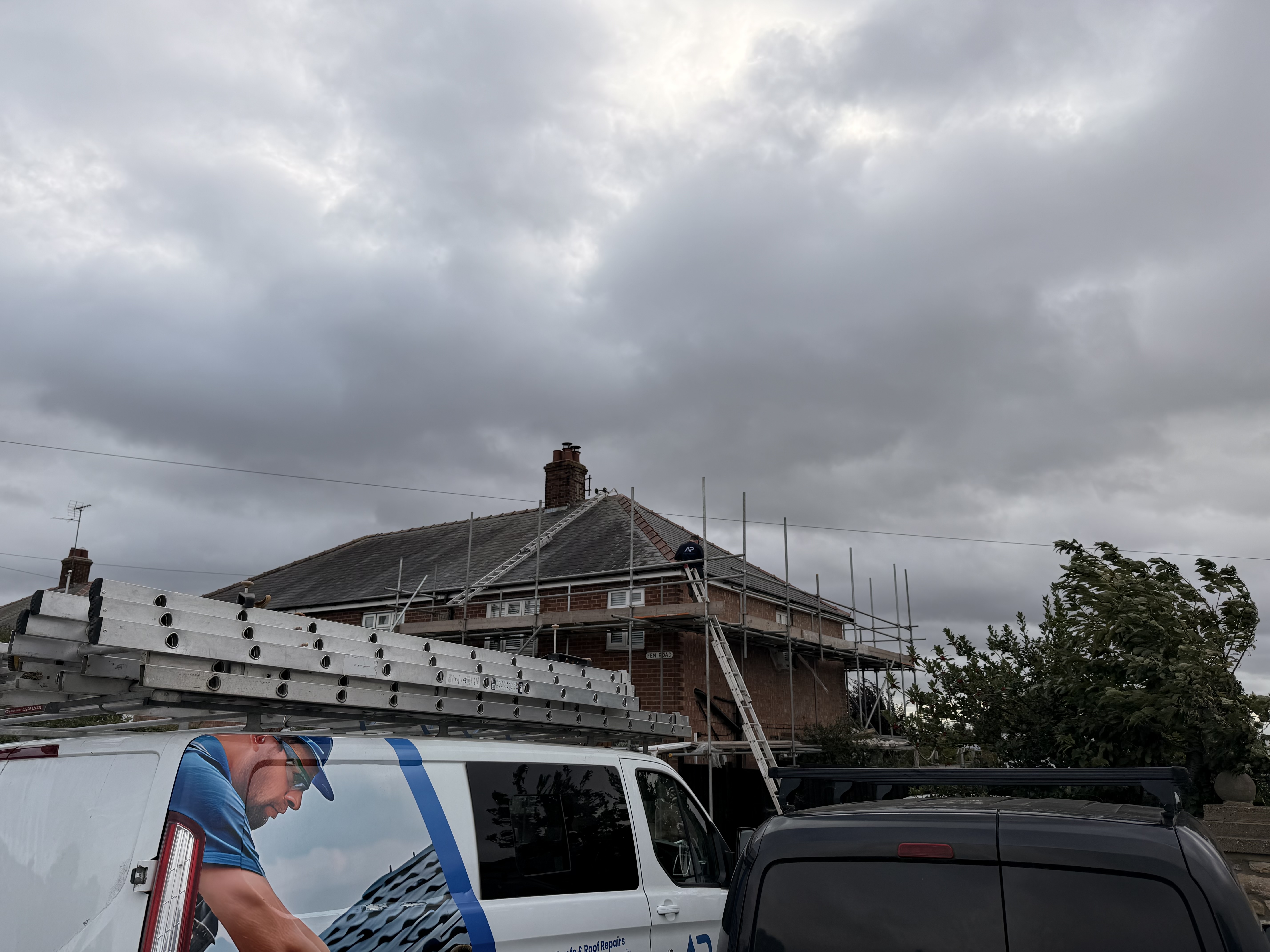 Scaffolded roof project beneath a cloudy sky