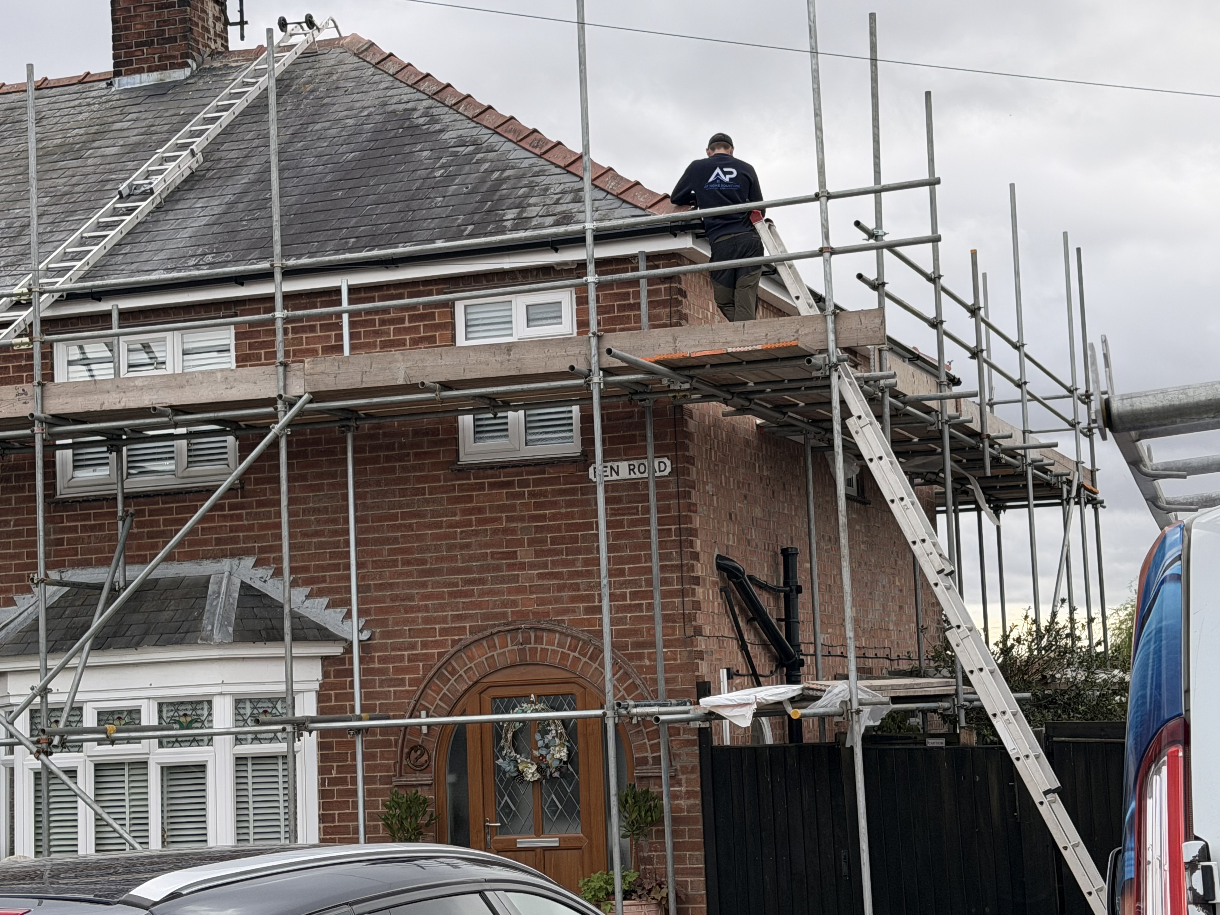 Roofer working above the front elevation from scaffold
