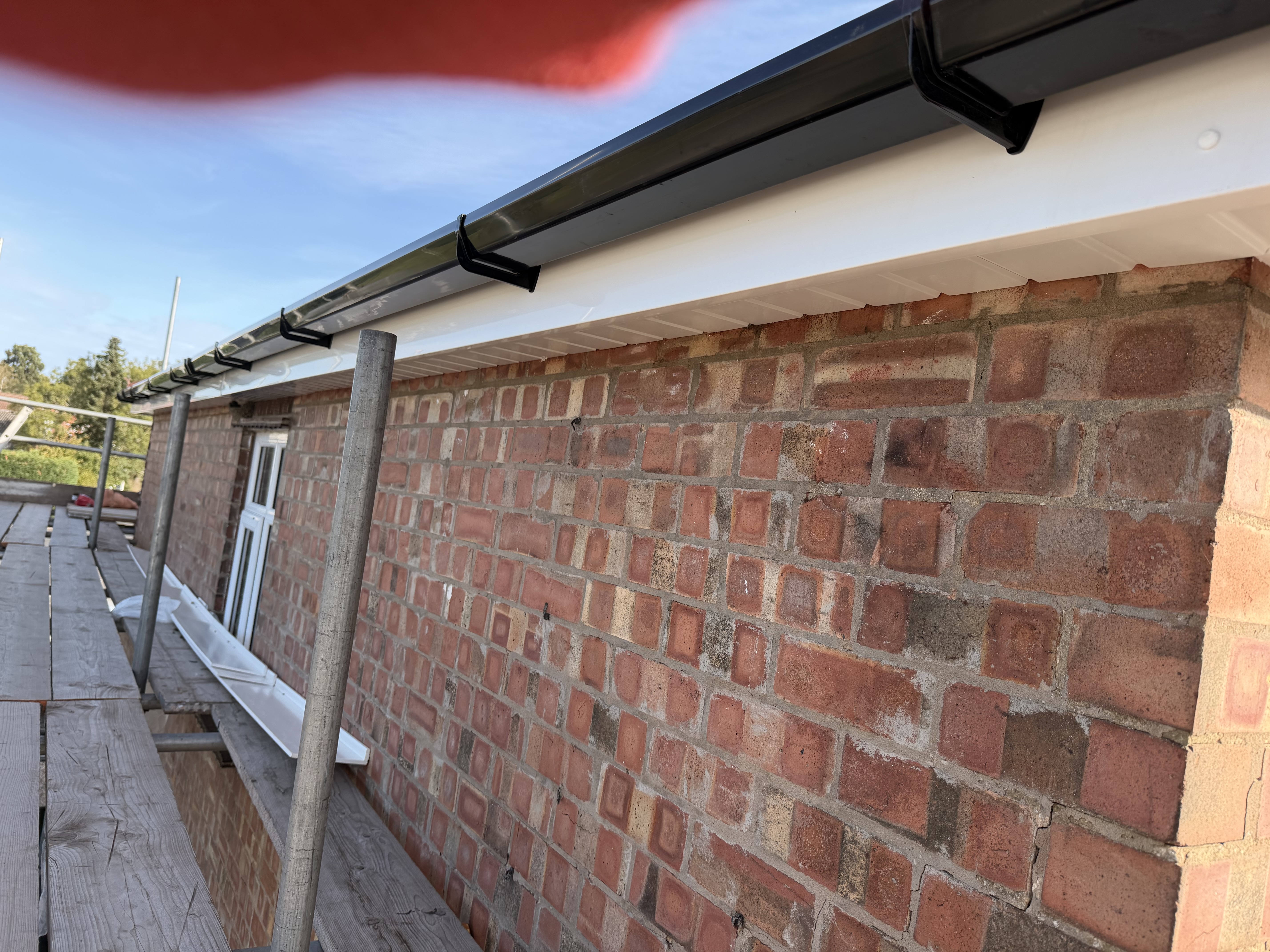 New white roof edge detail above brickwork