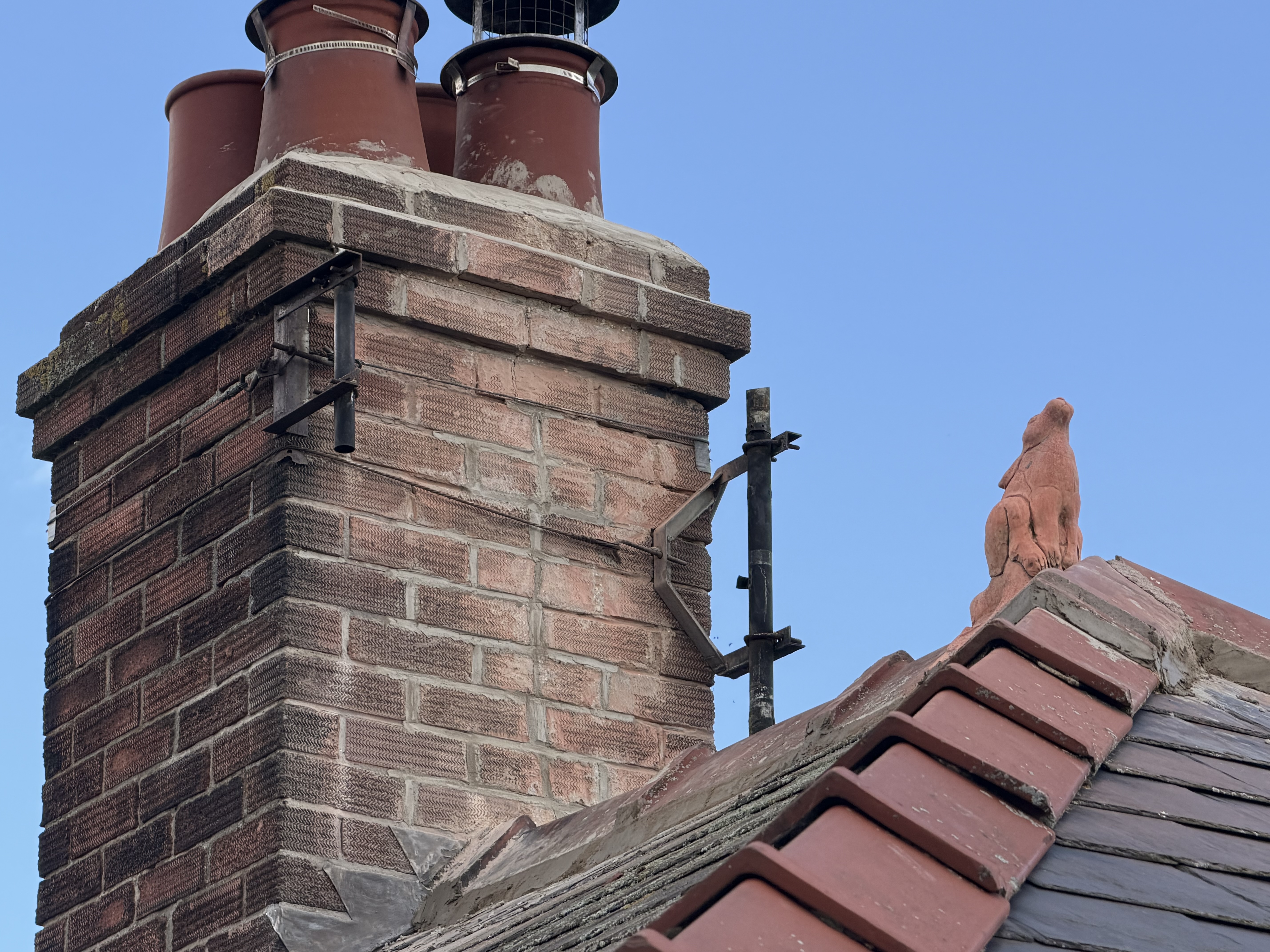 Brick chimney and tiled roof junction