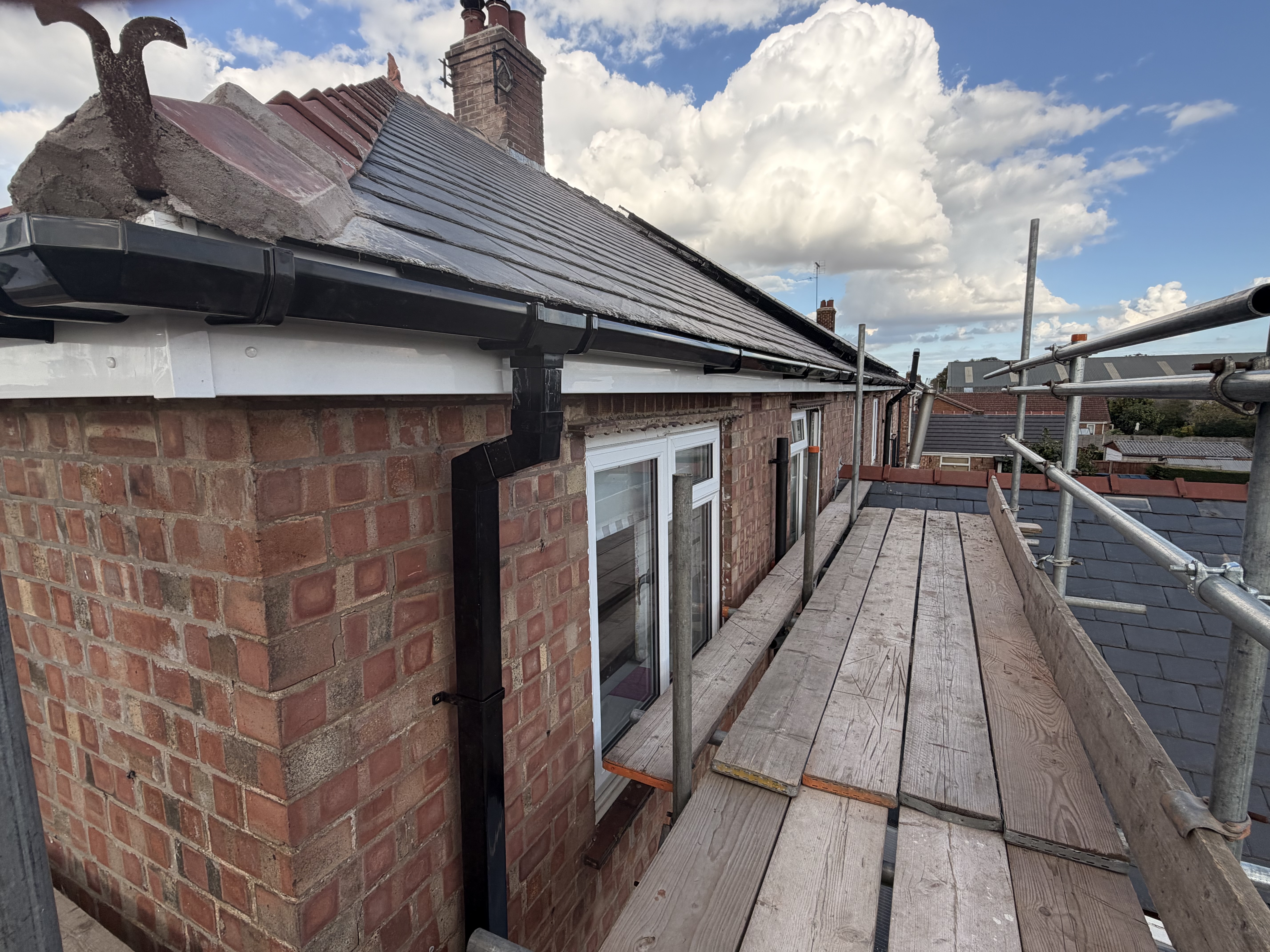 Completed side elevation with slate roof and scaffold walkway