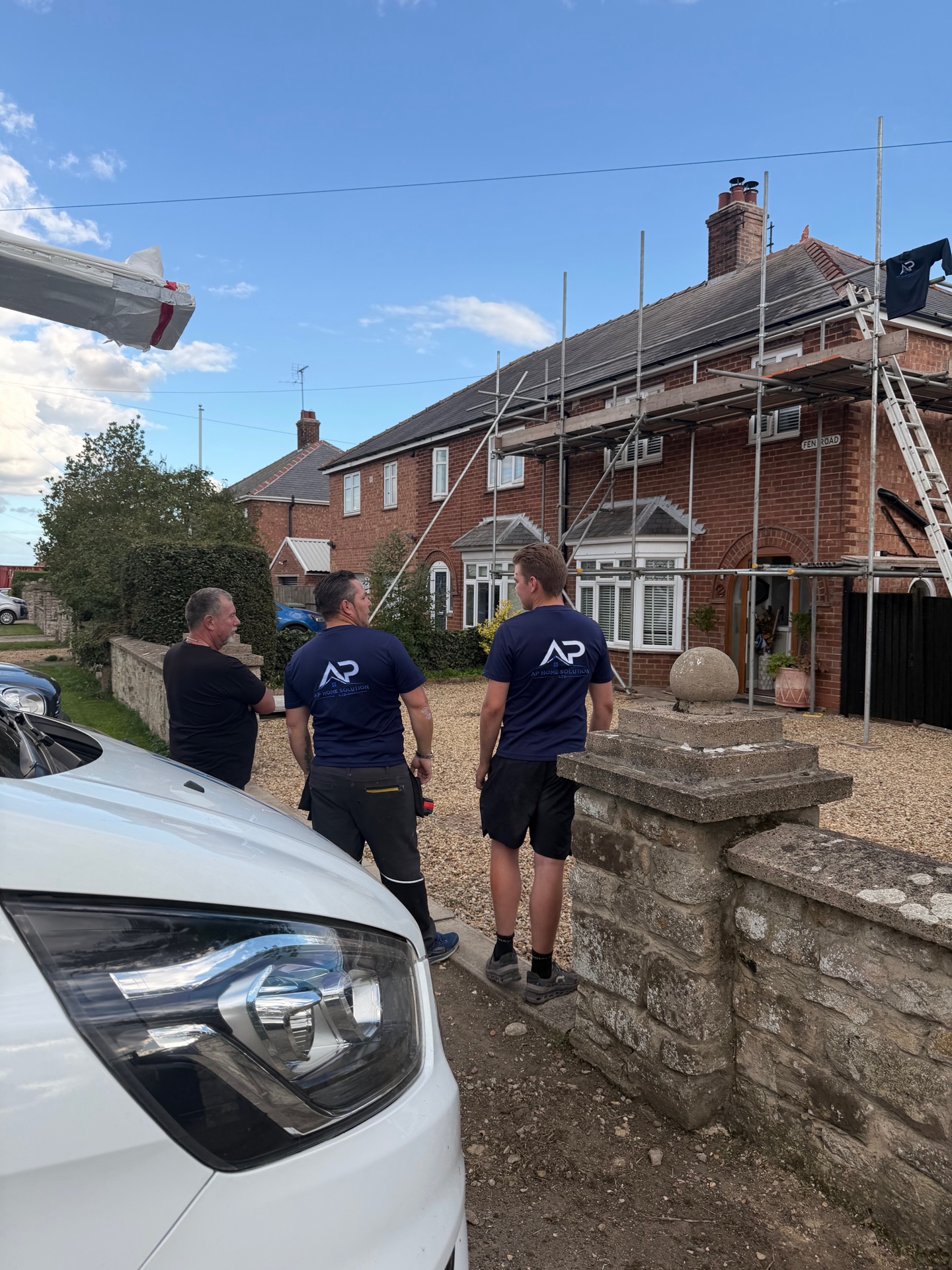 Roofing team and completed house frontage