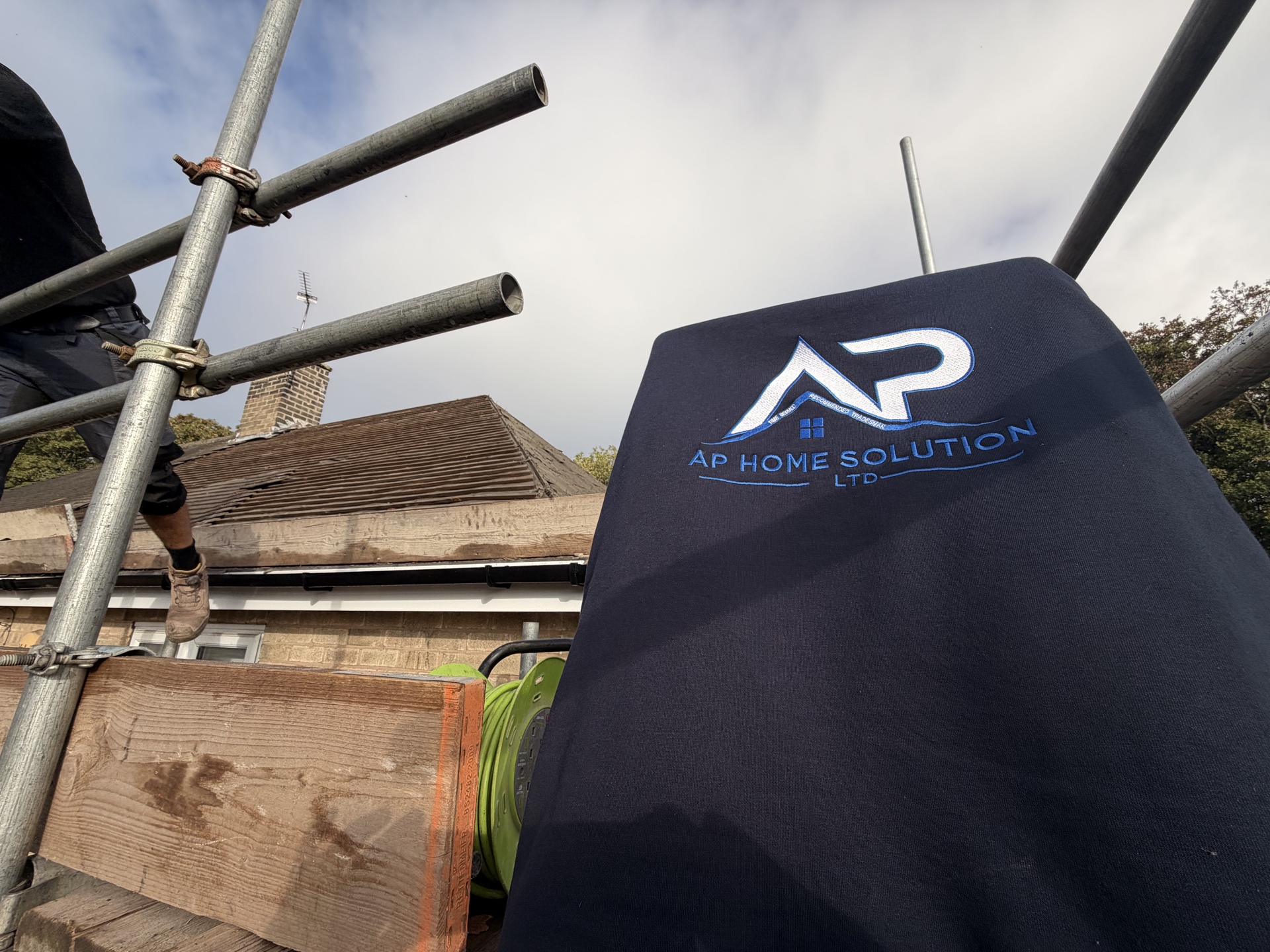 AP Home Solutions roofer working beside scaffold and roof tiles