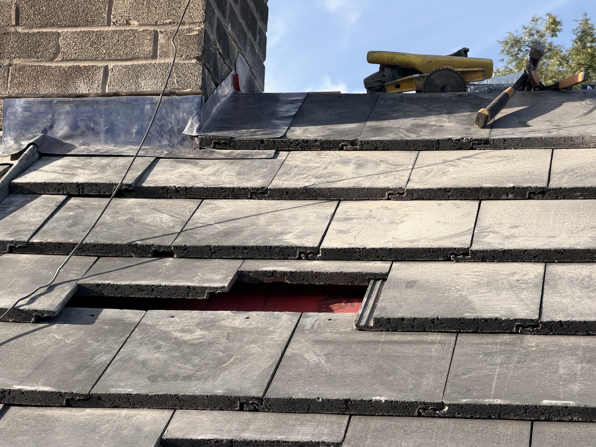 Close view of overlapping roof tiles beside a chimney