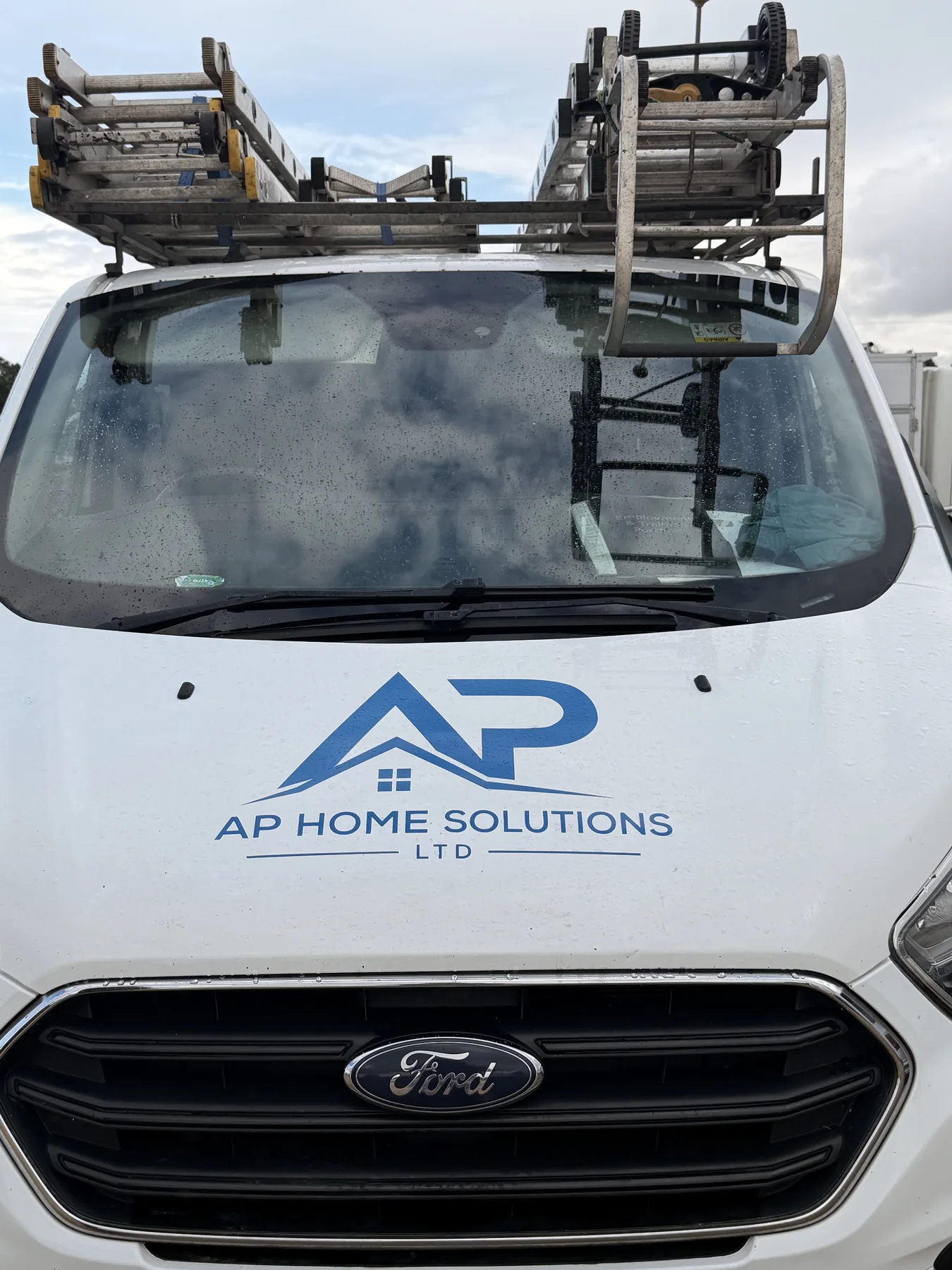 AP Home Solutions Ltd work van carrying roof ladders on its rack