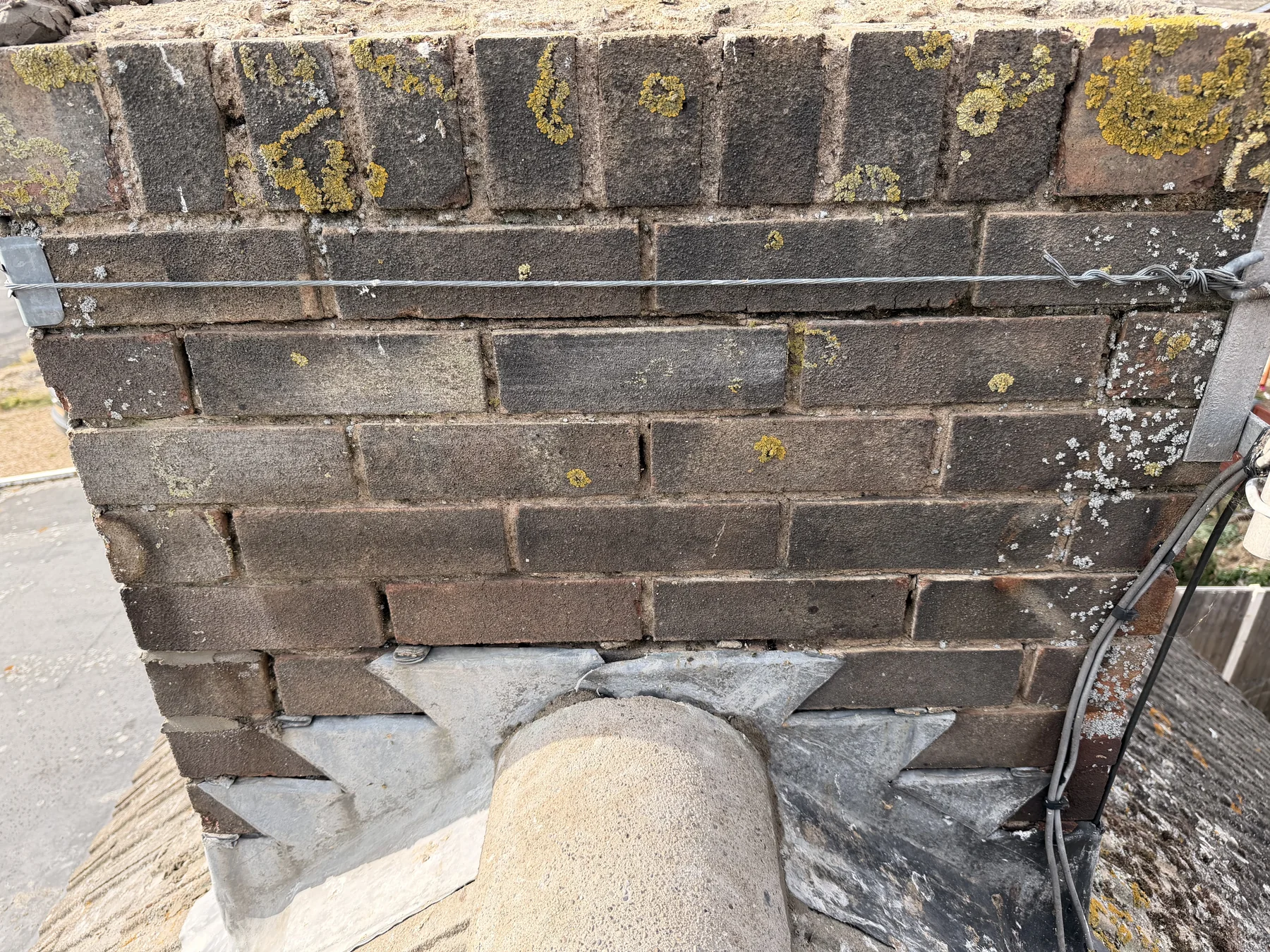 Close view of brickwork and leadwork around a pipe at roof level